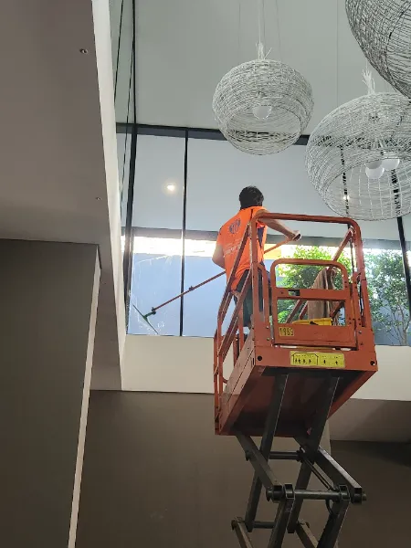 SWC operator on a scissor lift performing internal glass cleaning for a commercial building in Sydney