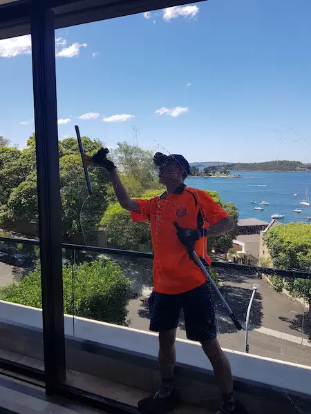 SWC professional window cleaner using a squeegee to clean residential windows at a Sydney home